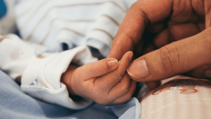 person holding newborn baby