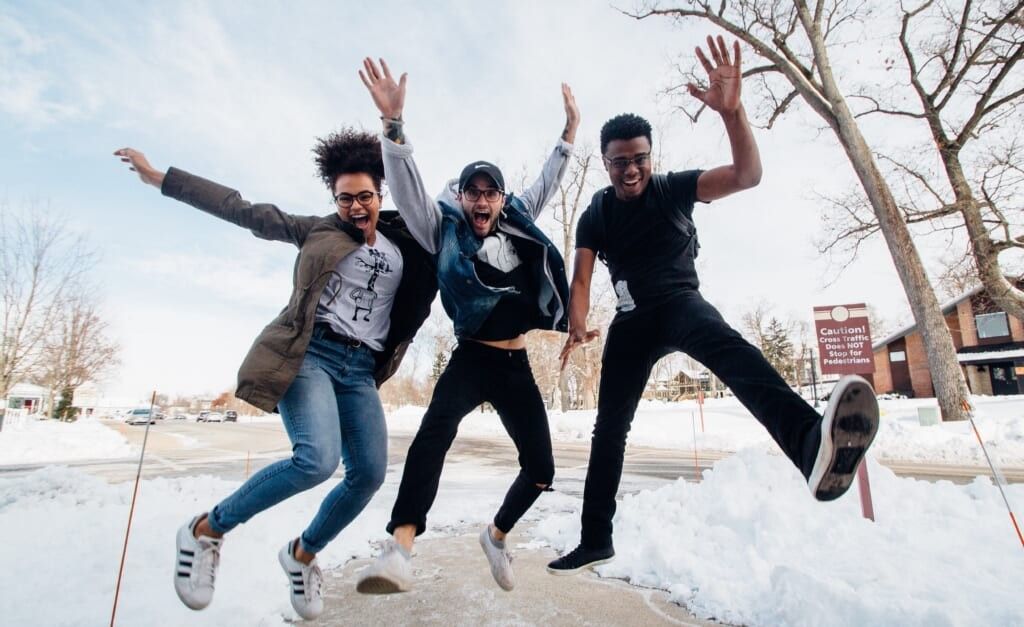 three friends dance and pose together