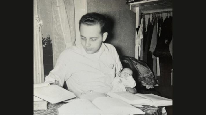 black and white photo of a young man holding a baby