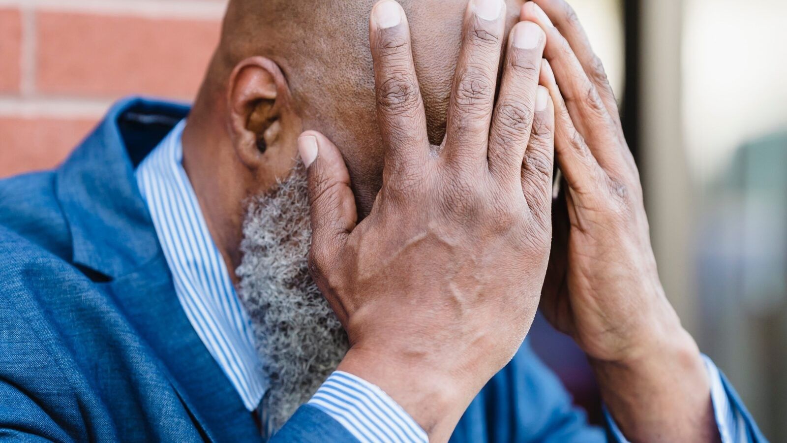 man covering his face with his hands