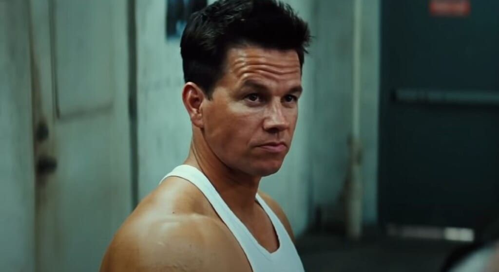 Mark Wahlberg in white tank top looking off camera.