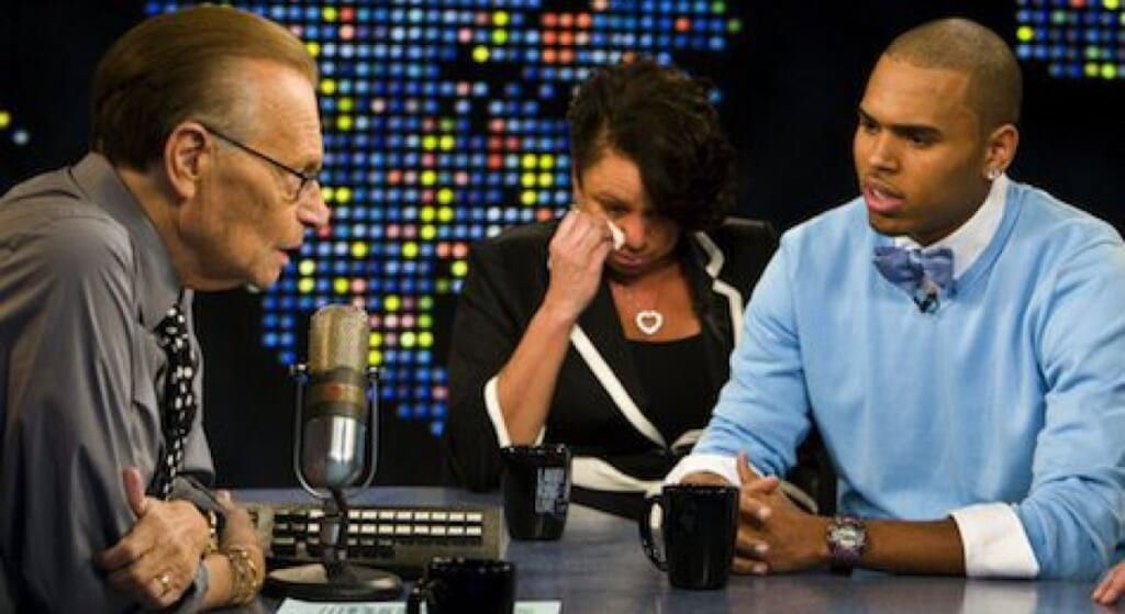 Chris Brown in blue sweater and bowtie next to mother Joyce Hawkins on Larry King interview.
