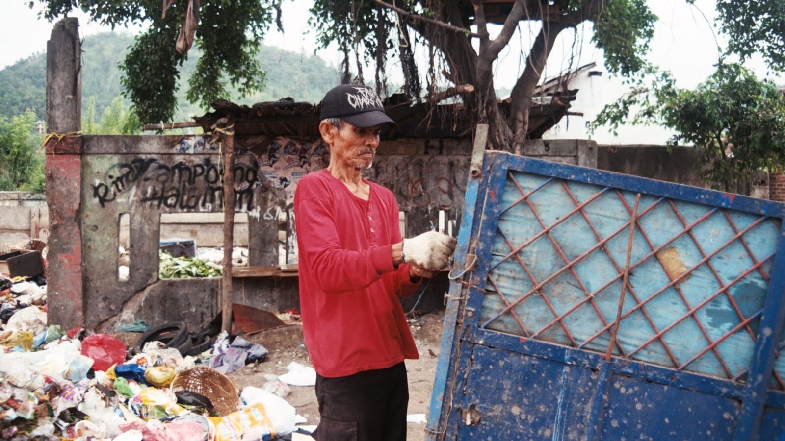 elderly man wearing a red long sleeve shirt working