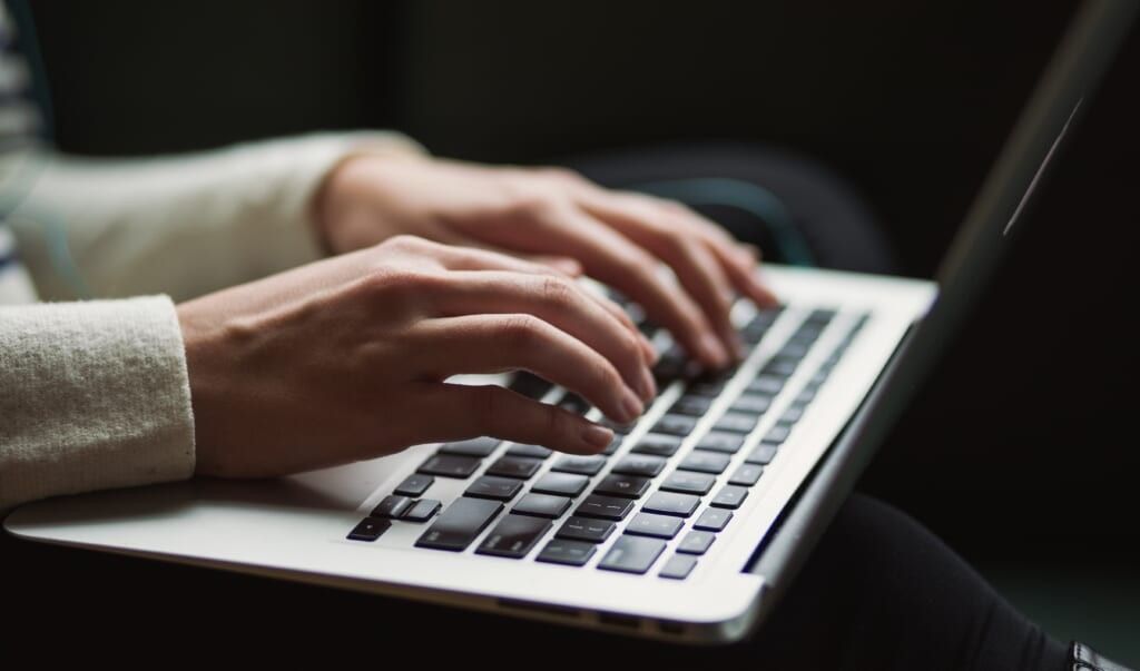 young person typing on laptop
