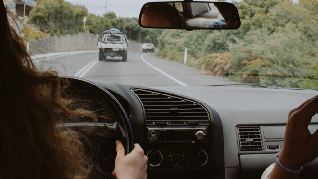 Woman behind wheel driving a car