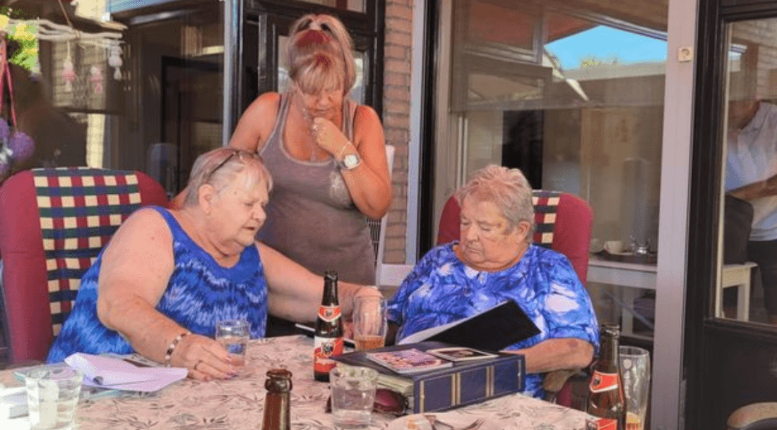 three people looking at photo album