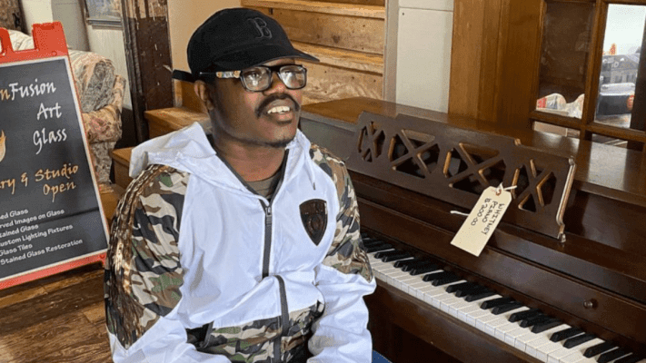man sitting next to a piano