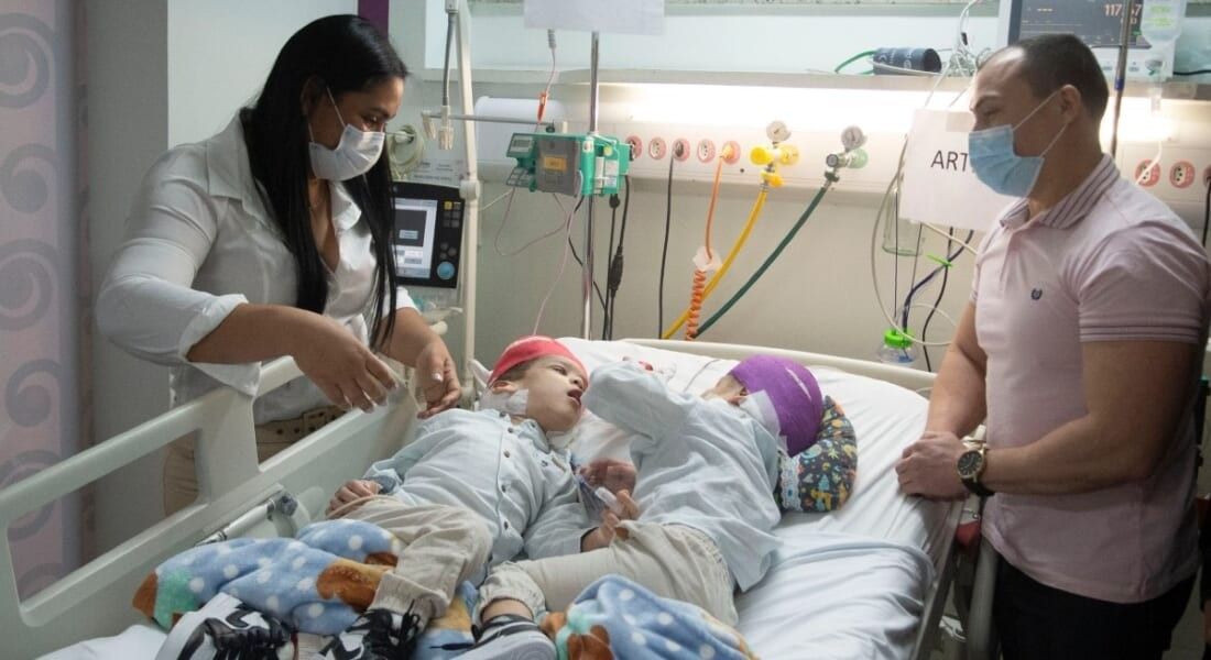 Lima parents looking at their sons after surgery.