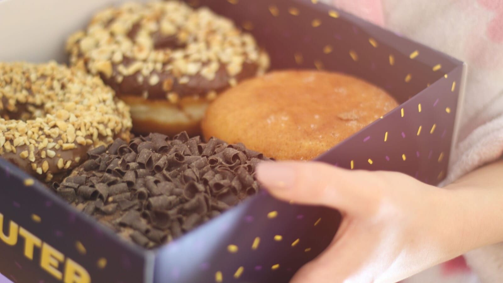 person holding a box of donuts