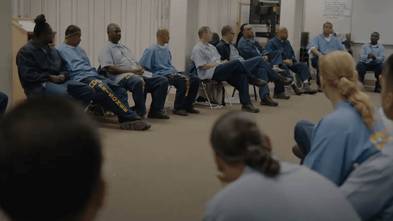 people sitting in chairs around a room