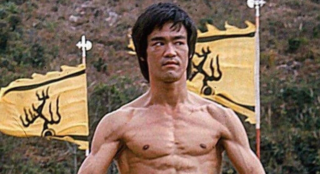 Bruce Lee posing in front of flags