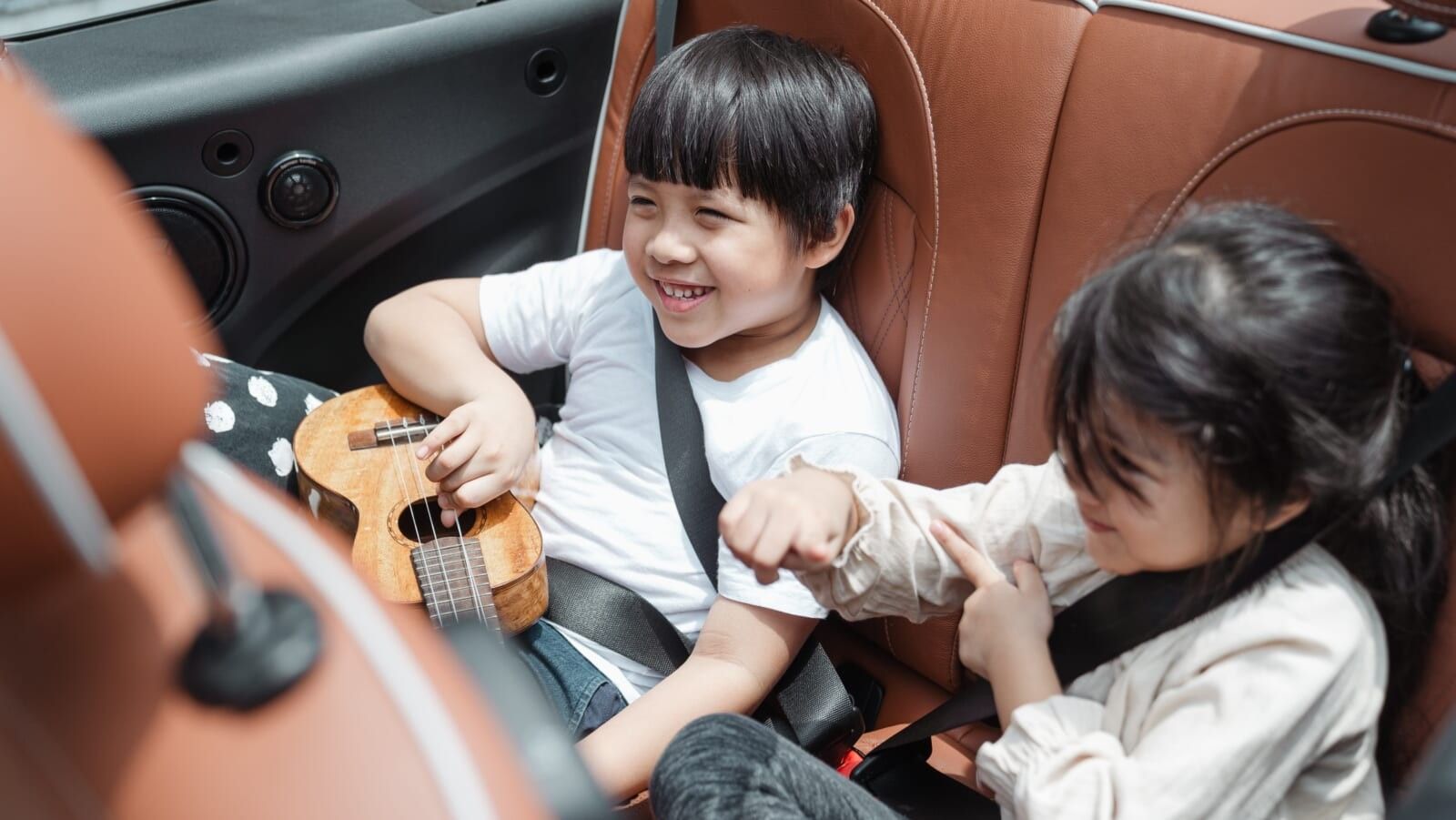 siblings sitting in the backseat