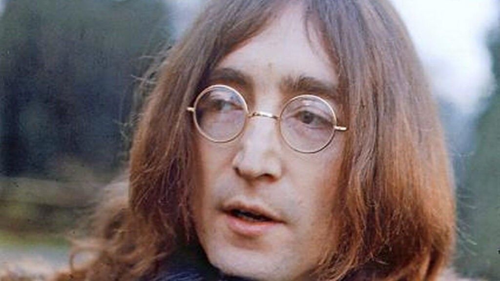 John Lennon with long hair and circle glasses