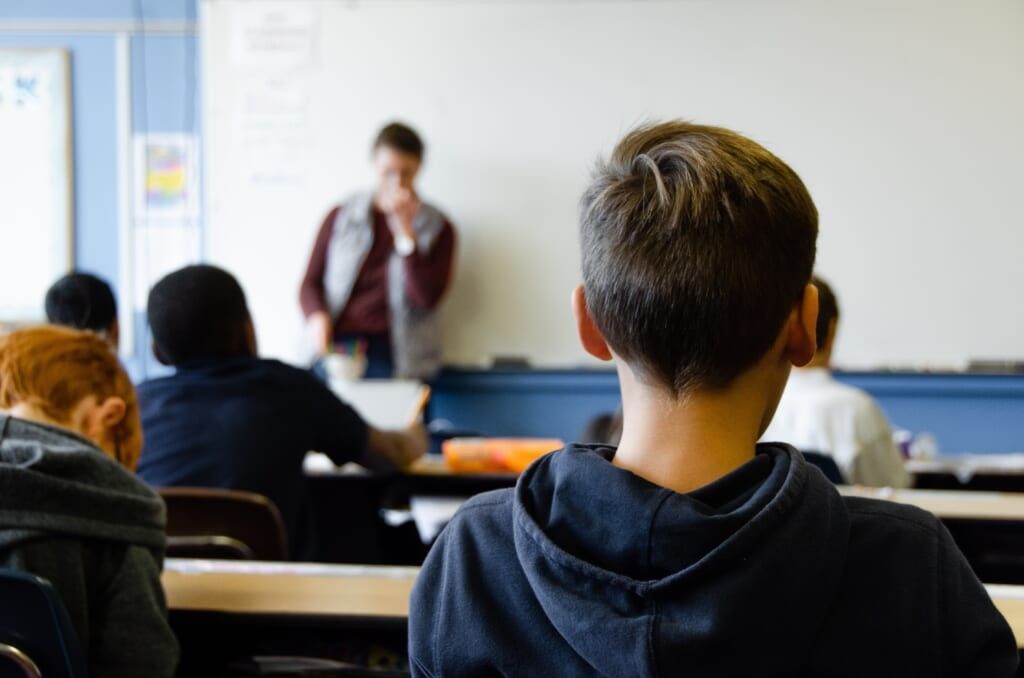 Over the shoulder view of student looking at a teacher at a white board