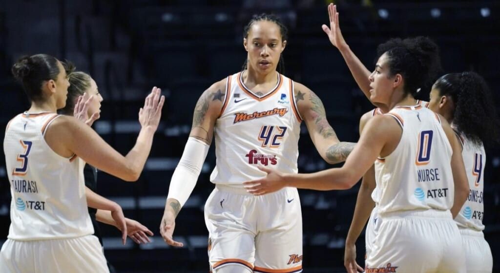 Brittney Griner and team high-fiving in white US basketball uniforms.