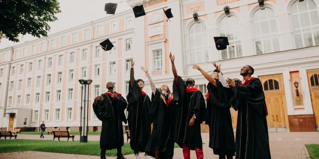 Group of friends throwing graduation caps in the air by Rut Miit on Unsplash