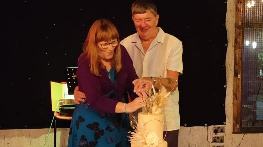 a man and woman cutting a cake