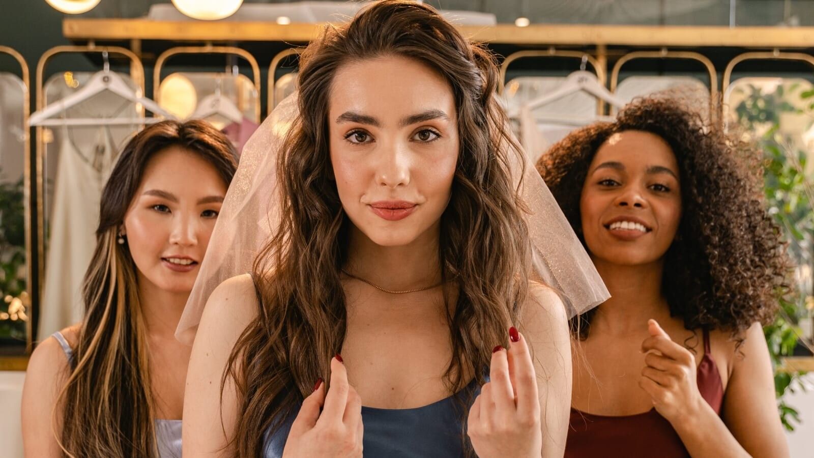 three women, one woman wearing a bridal veil 