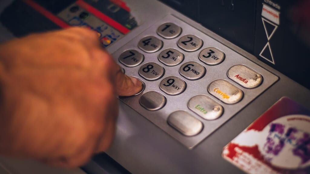 person entering pin on atm keypad