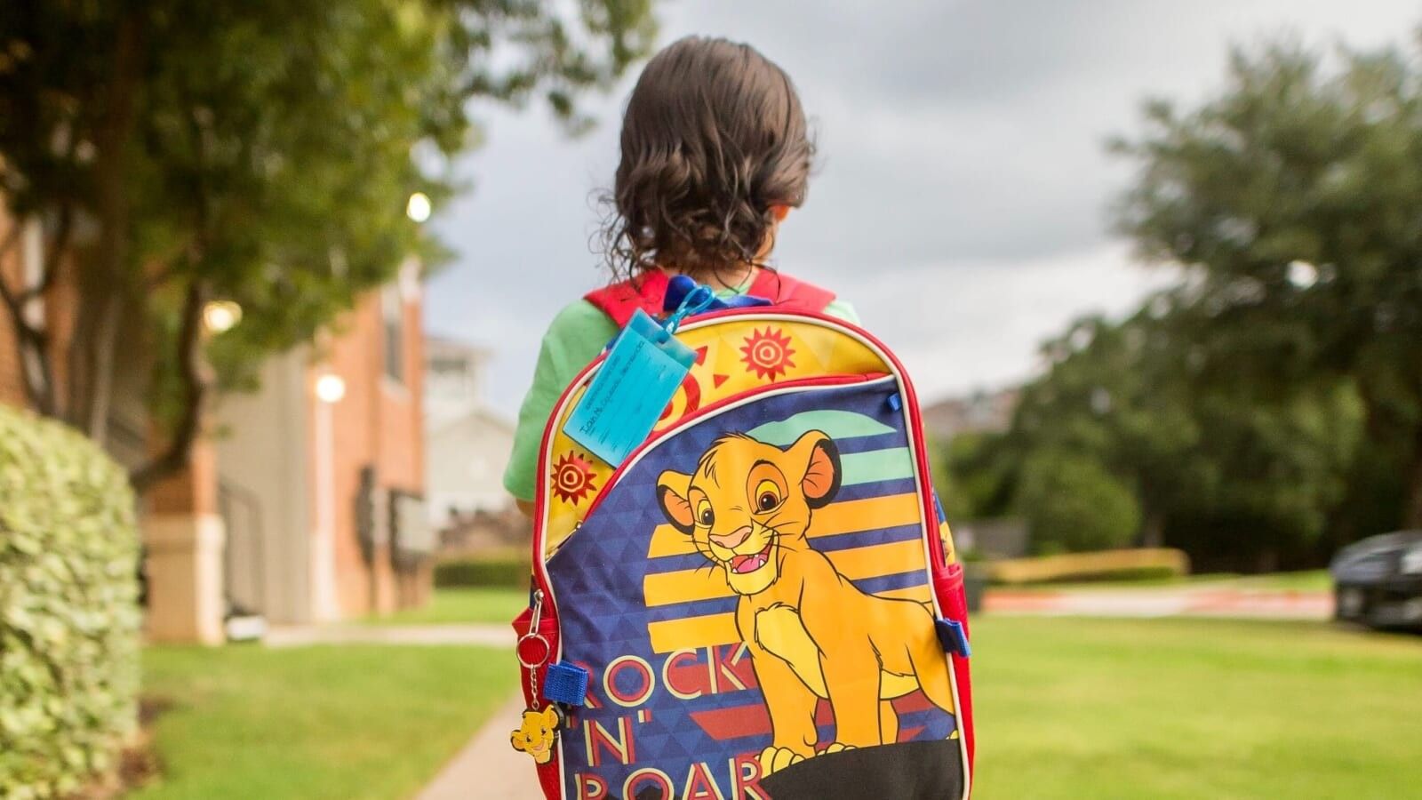 little boy wearing a backpack and walking