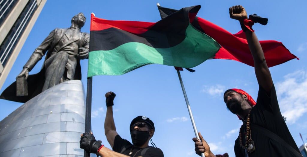 Protester chant near the Adam Clayton Powell Jr. statue during a Juneteenth celebration