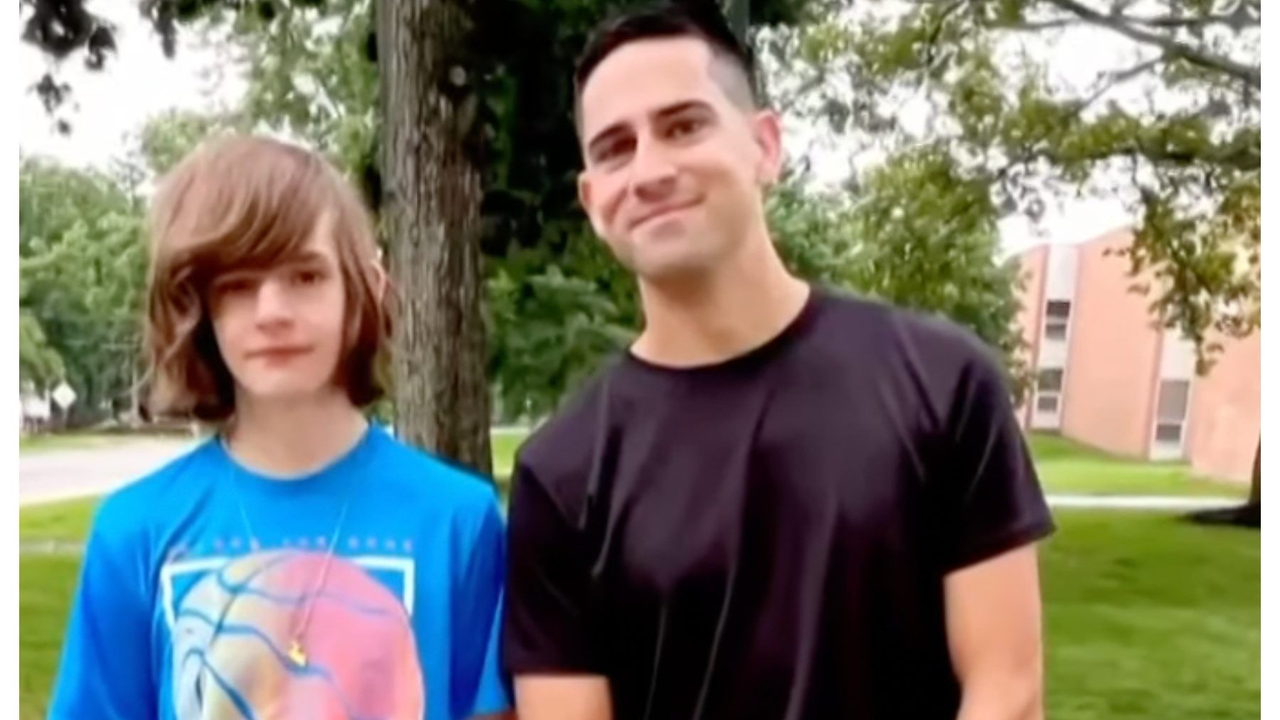 teen boy standing with his high school teacher