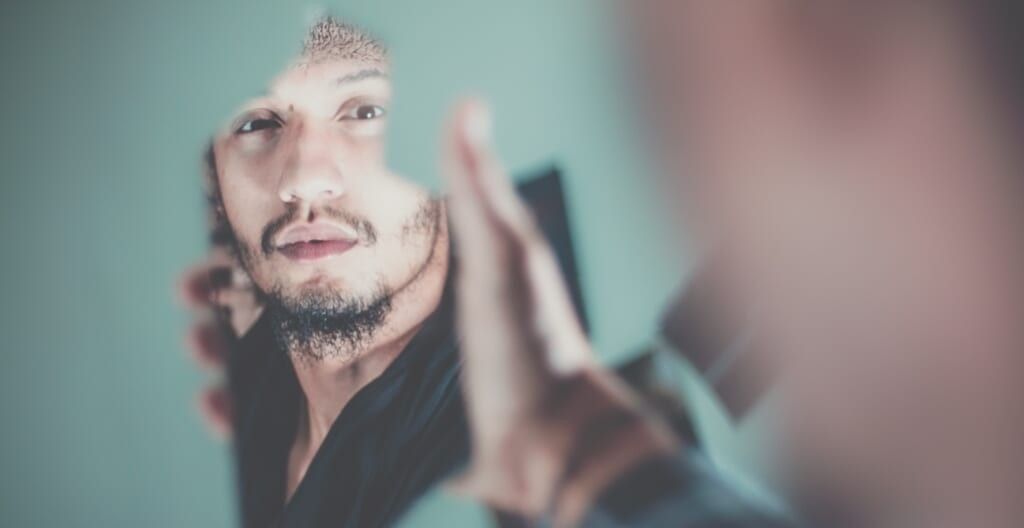 man looks in mirror