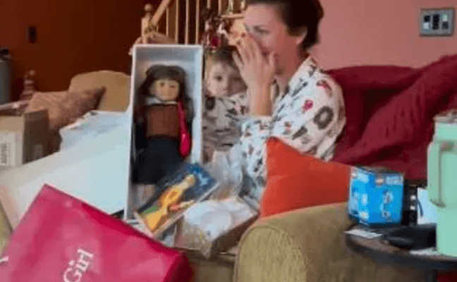 woman crying on a couch with a doll in her hands