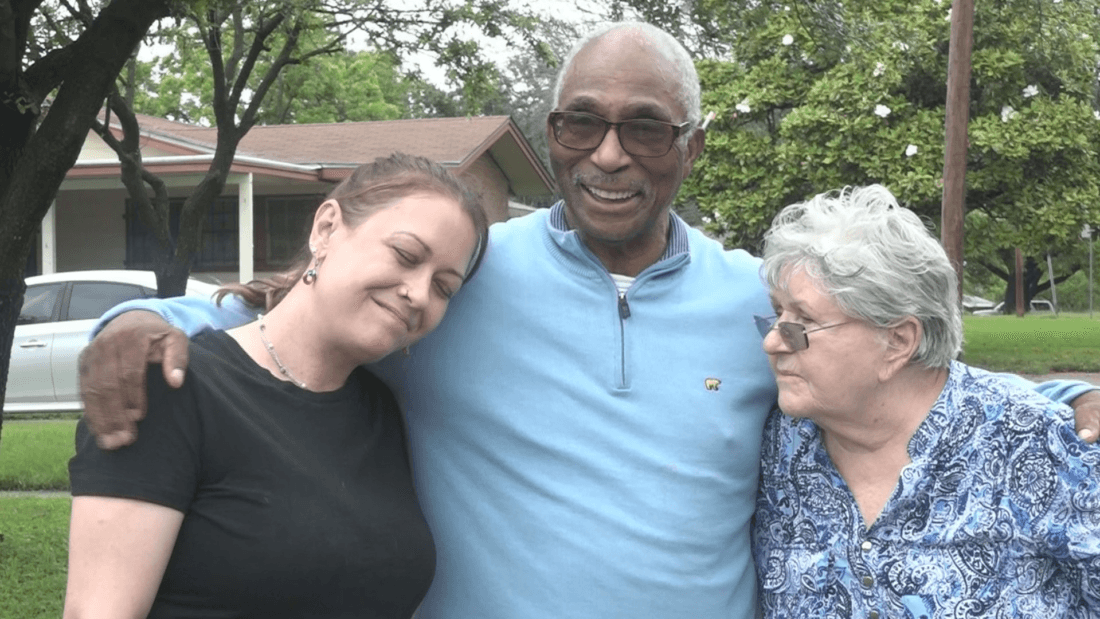 man standing in between a woman wearing a black shirt and an elderly woman