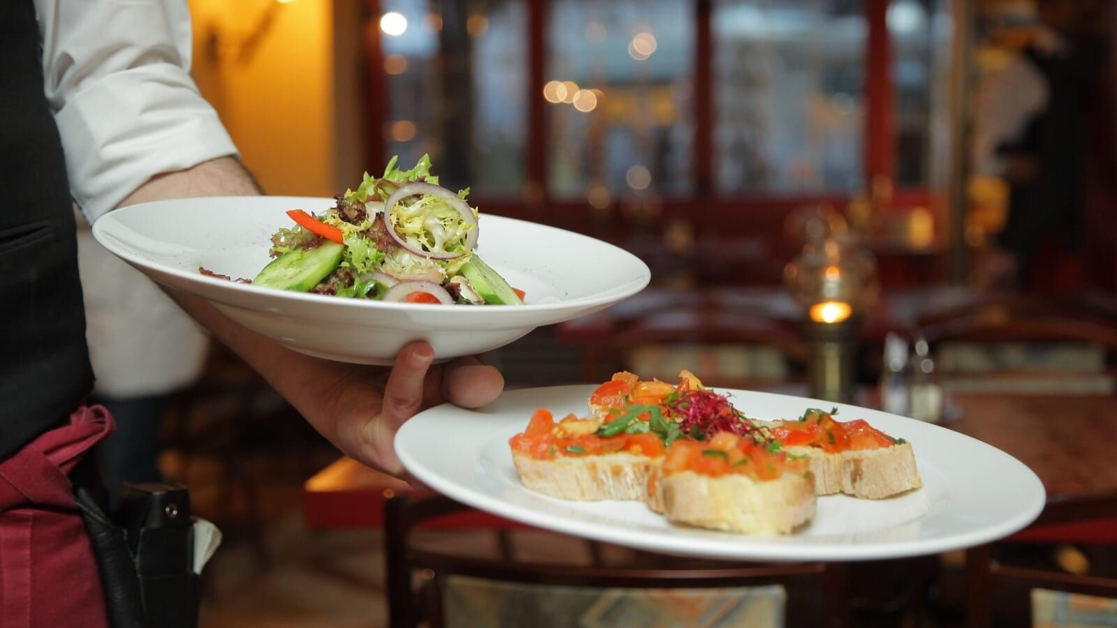 person holding 2 plates of food on his arm