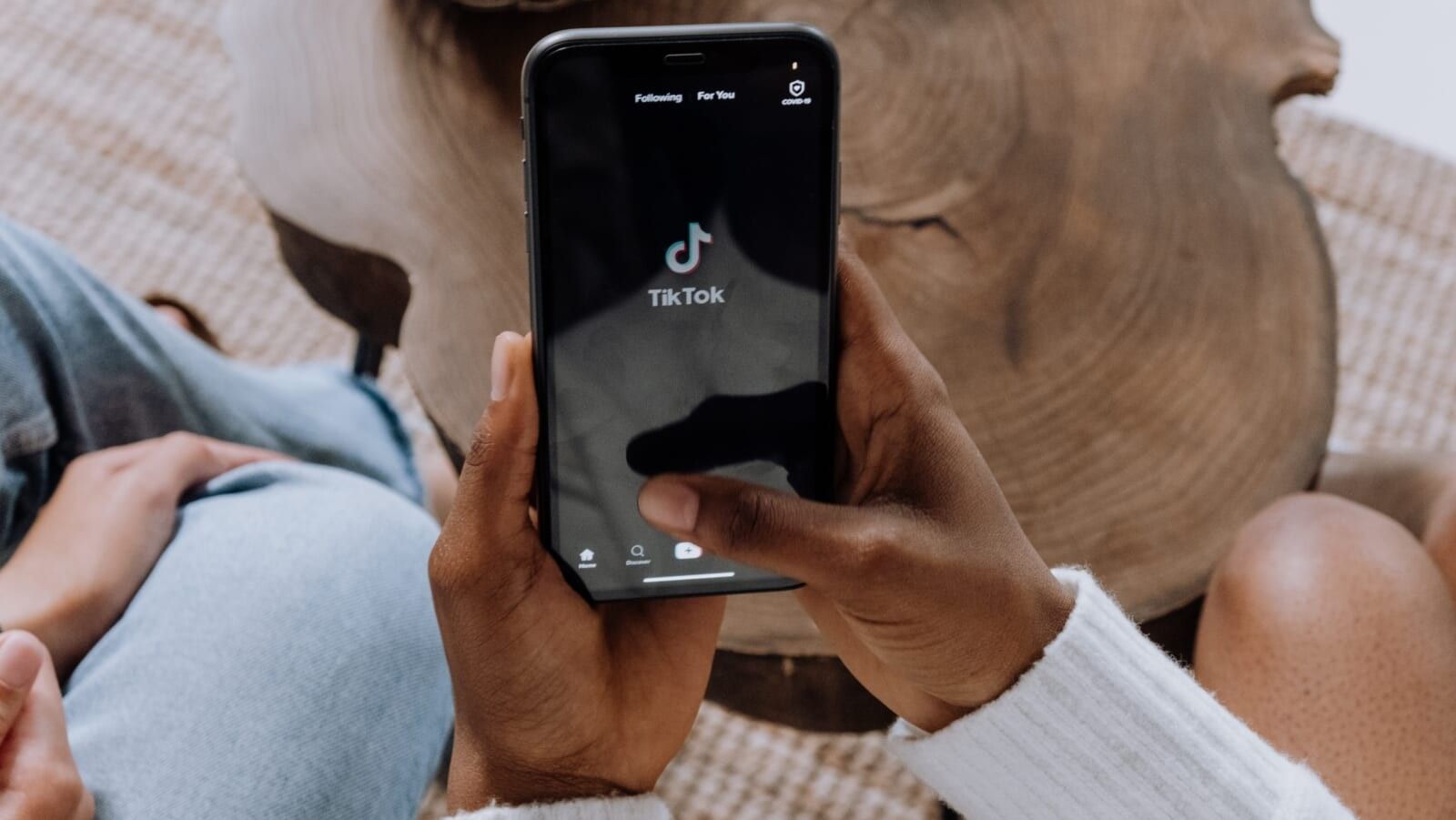 person holding a phone with the tiktok app open 