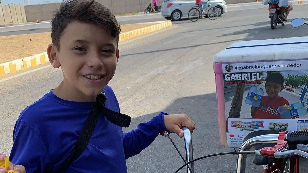 little boy wearing a blue shirt standing near a cycle