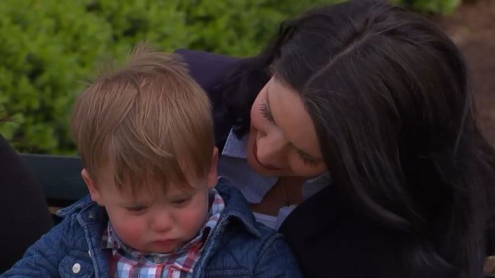 woman talking to a little boy sitting on her lap