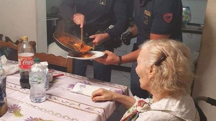 police officers making an elderly woman dinner