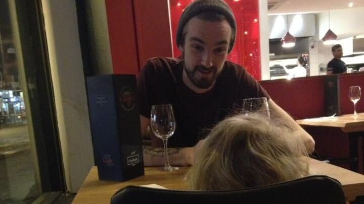 man in a beanie sitting at a table with a little girl