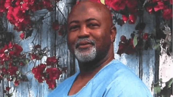 black man standing in front of flowers