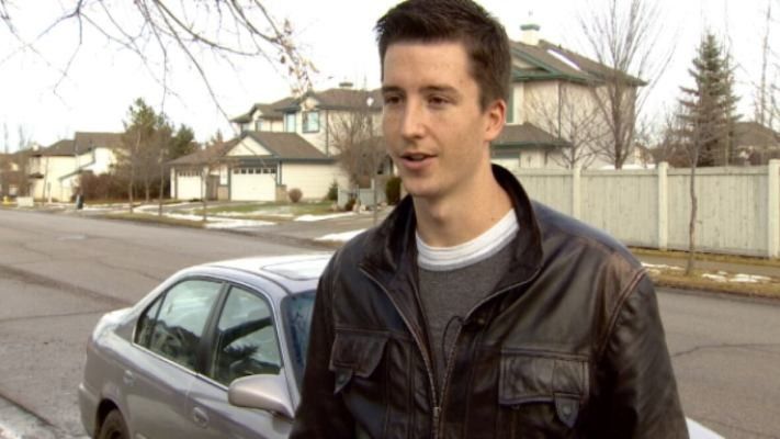 young man standing in front of a car
