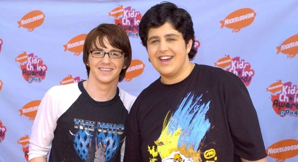 Drake Bell and Josh Peck smiling at the camera at a signing.
