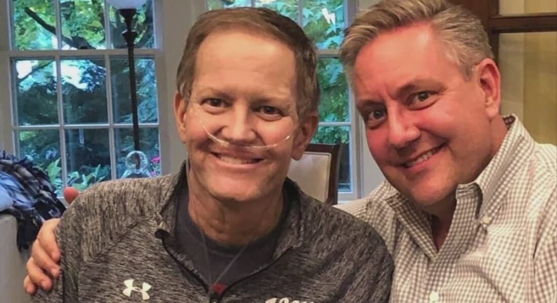 Chris Bradley posing with husband. 