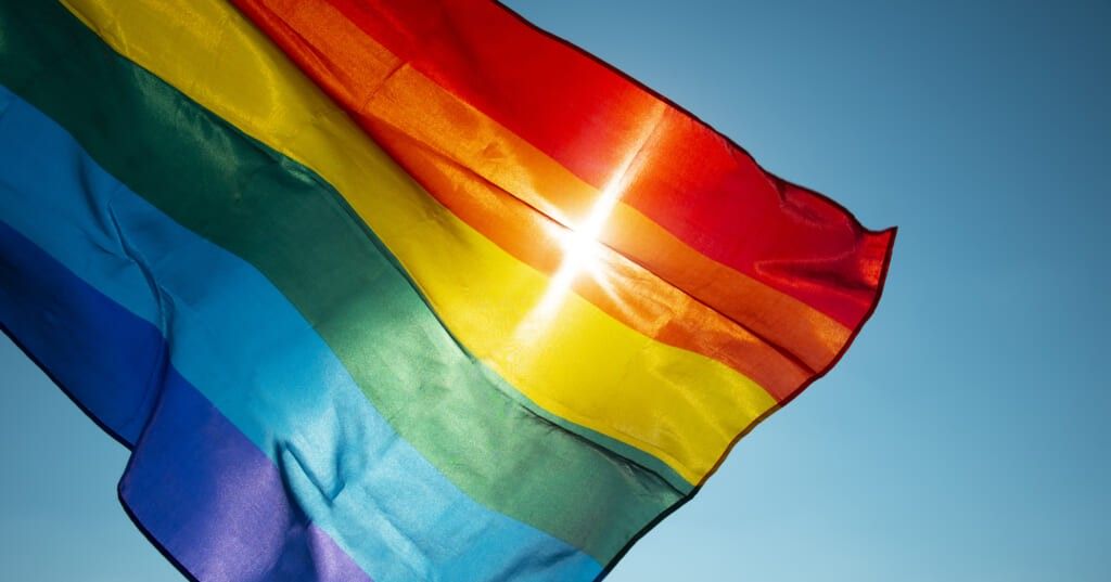 rainbow flag waving on the blue sky