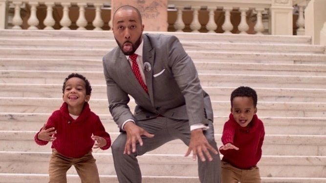 man in a suit with two young sons