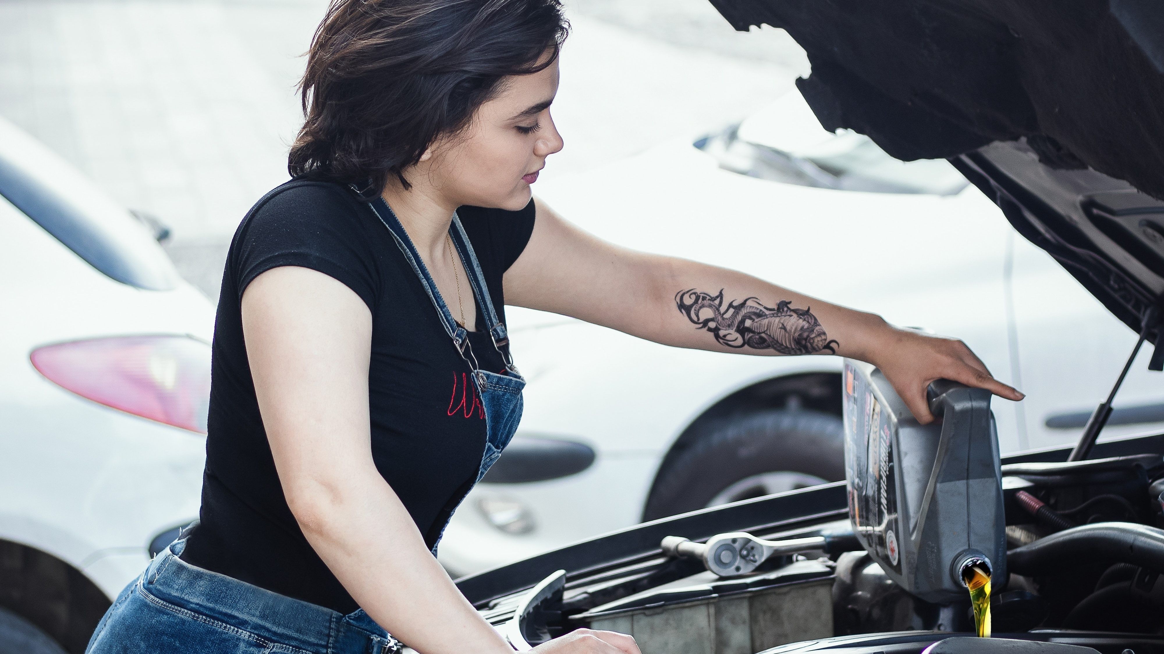 woman pouring engine oil into her car