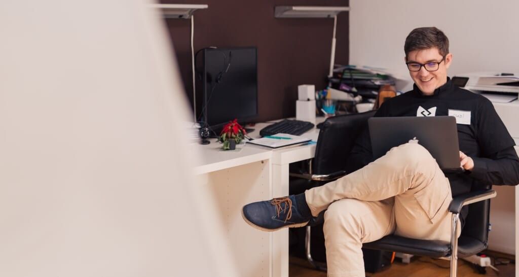 man smiles sitting in chair