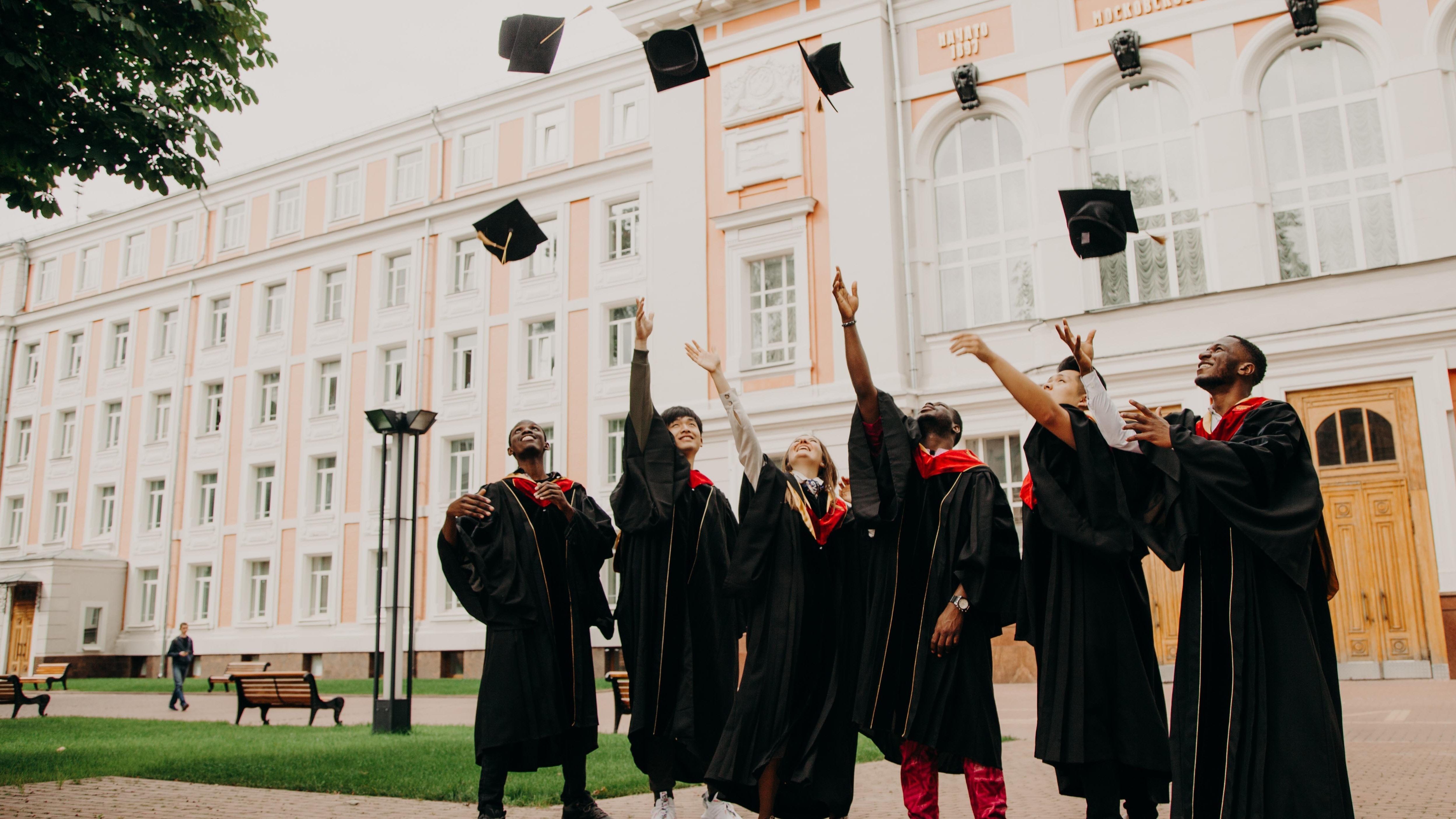 Group of friends throwing graduation caps in the air by Rut Miit on Unsplash