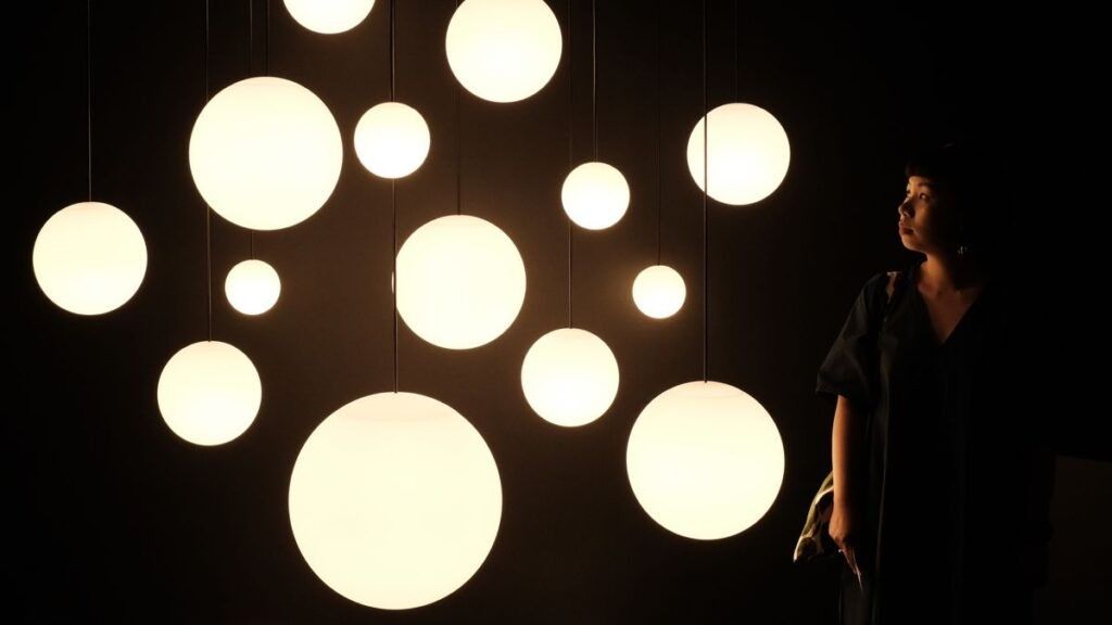 Woman looking at white light orb display 