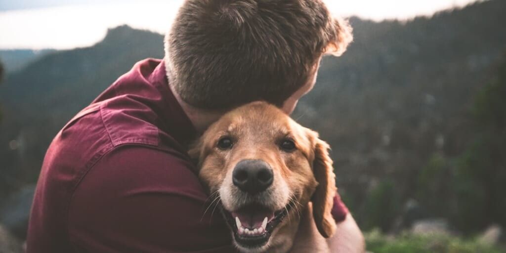 man hugging dog by eric ward from unsplash
