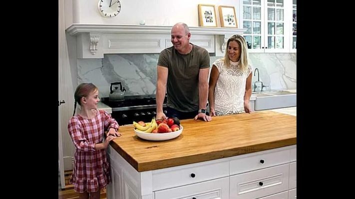man, woman, and little girl standing in the kitchen