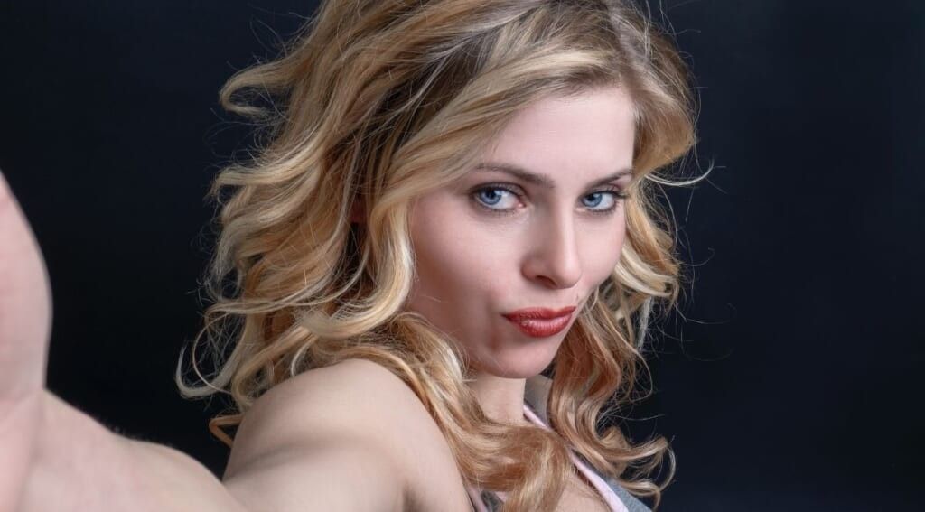 Woman pursing lips taking a selfie by Sander Sammy on Unsplash