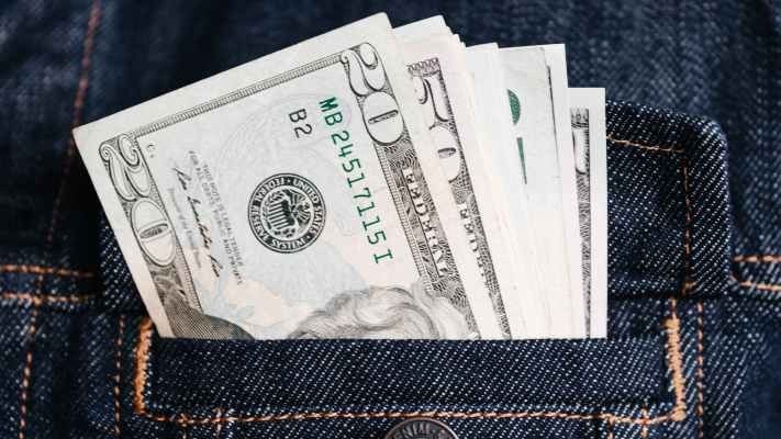 money in a denim jacket pocket