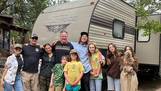 adults and kids standing in front of an RV